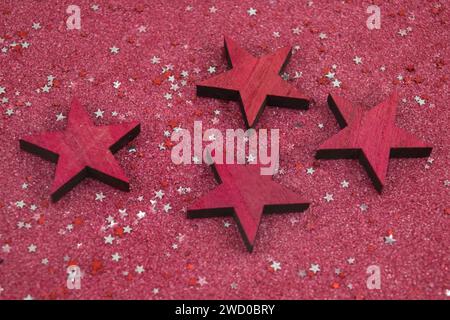 Rote Sterne mit kleinen silbernen und roten Sternen auf rotem Hintergrund, Weihnachtsdekoration Stockfoto