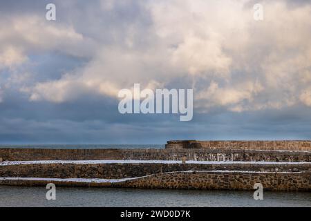 17. Januar 2024. Portsoy, Aberdeenshire, Schottland. Das ist Portsoy Hafen nach Schneestürmen und einem stürmischen Himmel. Hier war das Ende von Peaky BLI Stockfoto