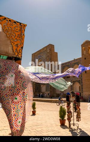 27. JUNI 2023, BUCHARA, USBEKISTAN: Schöne ethnische Stoffe, die mit dem Wind wehen, neben der alten Madrasah, Buchara, Usbekistan. Selektiver Fokus mit Stockfoto