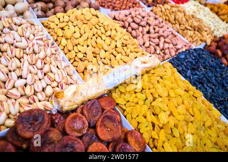 Detailansicht eines Händlers, der getrocknete Früchte, Nüsse und viele Gewürze, Kräuter und Gewürze verkauft. Auf dem wichtigsten lokalen Lebensmittelmarkt der sowjetischen Zeit, dem Grünen Basar. In Stockfoto