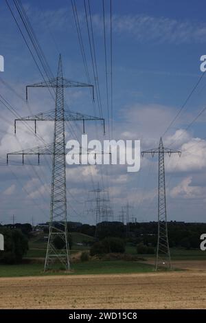 Eine Hochspannungsleitung nordwestlich von Frankfurt, Deutschland, neben der Autobahn A5. Ein dunkler bewölkter Himmel. Stockfoto