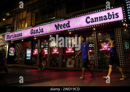 Bangkok, Thailand. Januar 2024. Menschen gehen am 17. Januar 2024 an einer Cannabisausgabe im Nana-Bezirk in Bangkok, Thailand, vorbei. Die neue thailändische Regierung hat ein Gesetz zur Änderung der geltenden Cannabisgesetzgebung eingeführt, um den Freizeitkonsum von Cannabis zu verbieten, nachdem das Land 2022 Cannabis für Freizeitzwecke entkriminalisiert hatte. (Kreditbild: © Valeria Mongelli/ZUMA Press Wire) NUR REDAKTIONELLE VERWENDUNG! Nicht für kommerzielle ZWECKE! Stockfoto