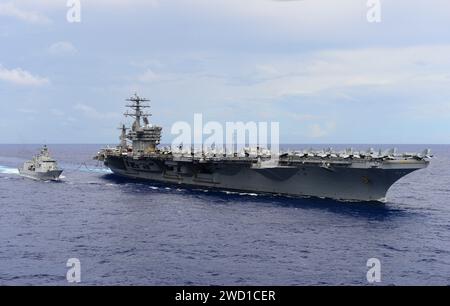 Die USS Nimitz führt zusammen mit der HMNZS Te Kaha eine Nachschubaktion auf See durch. Stockfoto