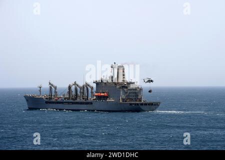 Ein MH-60S Sea Hawk Helikopter liefert eine Retrogradfahrt zur USNS Kanawha. Stockfoto