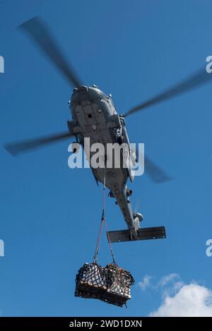 Ein MH-60S Sea Hawk Helikopter transportiert Vorräte während einer vertikalen Auffüllung. Stockfoto