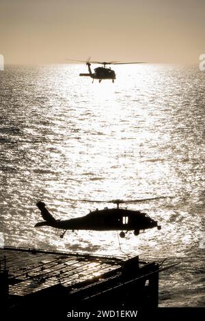 Zwei MH-60S Sea Hawk Hubschrauber transportieren Kampfmittel im Pazifischen Ozean. Stockfoto