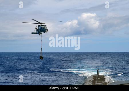 Ein MH-60R Sea Hawk liefert eine Nutzlast zum U-Boot mit ballistischer Rakete USS Henry M. Jackson. Stockfoto