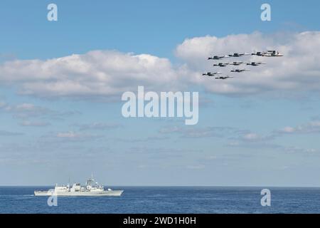 FA-18/G Super Hornets und ein E2-D Hawkeye Flugzeug fliegen über der Royal Canadian Navy Fregatte HMCS Winnipeg. Stockfoto
