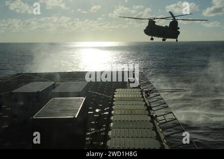 Ein CH-47 Chinook Hubschrauber fliegt über dem Flugdeck der USS Comstock. Stockfoto