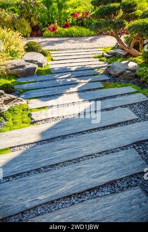 Zen-Steinweg in einem japanischen Garten mit Kies- und Rindenmulch und einheimischen Pflanzen Stockfoto