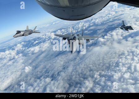 Eine Royal Air Force F-35 Lightning II, die US Air Force F-15E Strike Eagle und die französische Air Force Rafale fliegen hinter einem KC-135 Stratotanker. Stockfoto