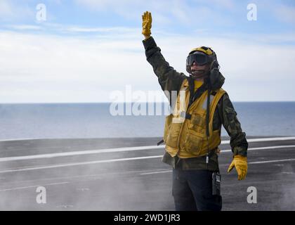 Aviation Boatswains Mate leitet die Besatzung einer E-2C Hawkeye auf dem Flugzeugträger USS Carl Vinson. Stockfoto