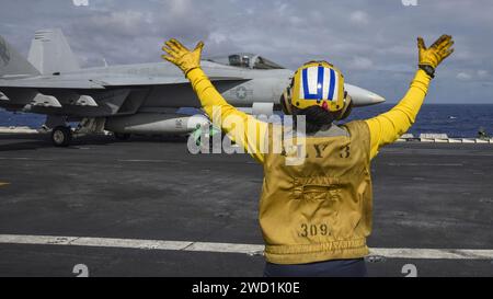Aviation Boatswains Mate leitet eine F/A-18E Super Hornet an Bord des Flugzeugträgers USS Carl Vinson. Stockfoto