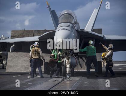Die Matrosen bereiten eine F/A-18F Super Hornet für den Start von der USS Carl Vinson vor. Stockfoto