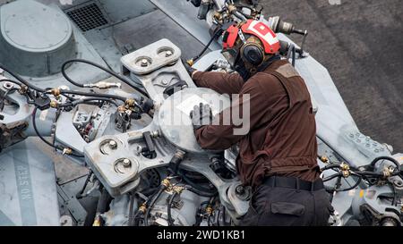 Marine Air Crewman führt Wartungsarbeiten an einem MH-60S Sea Hawk Hubschrauber durch. Stockfoto