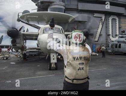 Seeleute bereiten sich darauf vor, ein E-2C Hawkeye Frühwarn- und Kontrollflugzeug an Bord der USS Carl Vinson zu transportieren. Stockfoto