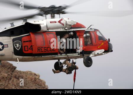 Seeleute führen Übungen zur Bergung von Klippen mit einem MH-60S Sea Hawk Hubschrauber durch. Stockfoto