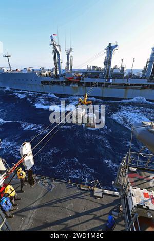 Seeleute an Bord der USS Hue City führen eine Auffüllung mit der USNS Joshua Humphreys durch. Stockfoto