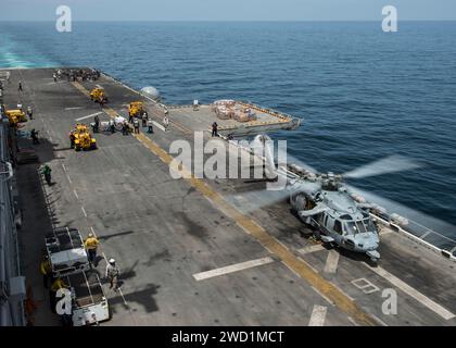 Ein MH-60S Sea Hawk landet während einer vertikalen Auffüllung auf dem Flugdeck der USS Makin Island. Stockfoto