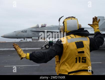 Boatswain's Mate leitet eine F/A-18C Hornet an Bord des Flugzeugträgers USS Nimitz. Stockfoto
