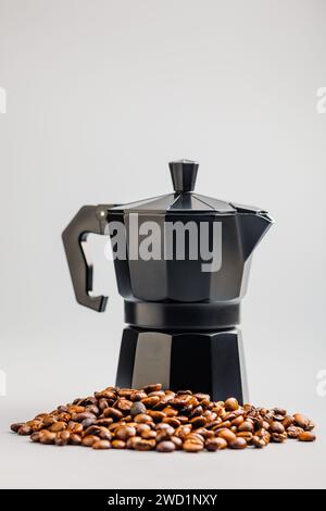 Bialetti Mokakanne. Kaffeemaschine und Kaffeebohnen auf grauem Hintergrund. Stockfoto
