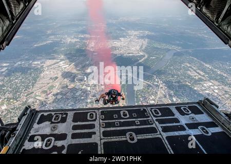 Ein Mitglied des Fallschirmdemonstrationsteams der US Navy spürt Rauch auf, während er aus einem C-130 Hercules springt. Stockfoto