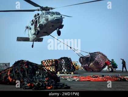 Seeleute erhalten Vorräte von einem MH-60S Sea Hawk Hubschrauber an Bord der USS Nimitz. Stockfoto