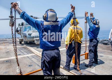 Seeleute entfernen Keile und Ketten von einem MH-60S Sea Hawk Hubschrauber an Bord der USS Princeton. Stockfoto