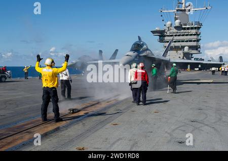 Die Matrosen positionieren eine F/A-18F Super Hornet, bevor sie an Bord der USS Harry S. Truman starten. Stockfoto