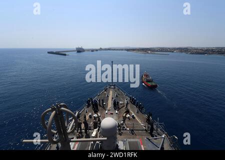 Ein griechisches Schleppboot hilft dem Amphibienschiff USS Carter Hall beim Anfahren in den Hafen von Rhodos, Griechenland. Stockfoto