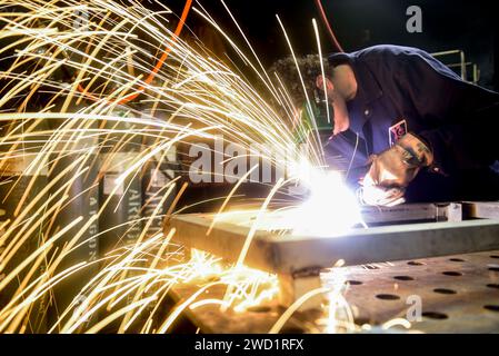 Der Schiffsreparaturtechniker schneidet Stahl an Bord des Flugzeugträgers USS Nimitz. Stockfoto