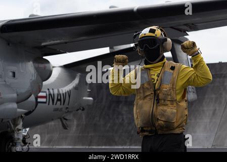 Boatswain's Mate signalisiert eine E-2C Hawkeye auf dem Flugdeck der USS Harry S. Truman. Stockfoto