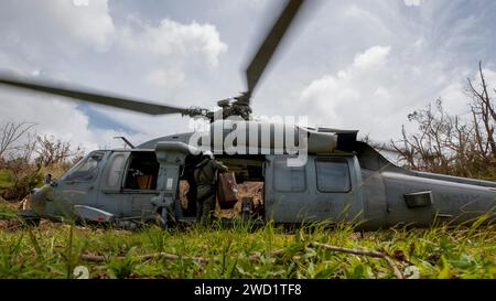 Der Marine Aircrewman lädt Gepäck in einen MH-60S Sea Hawk Hubschrauber. Stockfoto