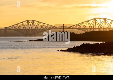 Ein wunderschöner Sonnenuntergang im Firth of Forth mit Blick auf Downing Point in Dalgety Bay und die Forth Bridge. Stockfoto