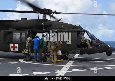 Patienten gehen an Bord eines Hubschraubers DER US Army UH-60 Black Hawk an Bord der USNS Comfort. Stockfoto