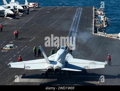 Die Matrosen bereiten sich darauf vor, eine F/A-18F Super Hornet an Bord des Flugzeugträgers USS Nimitz zu starten. Stockfoto