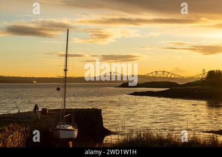 Ein wunderschöner Sonnenuntergang im Firth of Forth mit Blick auf Downing Point in Dalgety Bay und die Forth Bridge. Stockfoto