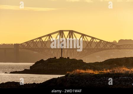 Ein wunderschöner Sonnenuntergang im Firth of Forth mit Blick auf Downing Point in Dalgety Bay und die Forth Bridge. Stockfoto