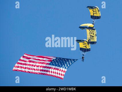 Mitglieder des Fallschirmteams der US Navy, die Leap Frogs, bauen eine Diamantenformation mit amerikanischer Flagge. Stockfoto