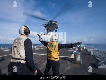 Boatswain's Mate meldet einen MH-60S Sea Hawk Hubschrauber, der von der USS Preble startet. Stockfoto