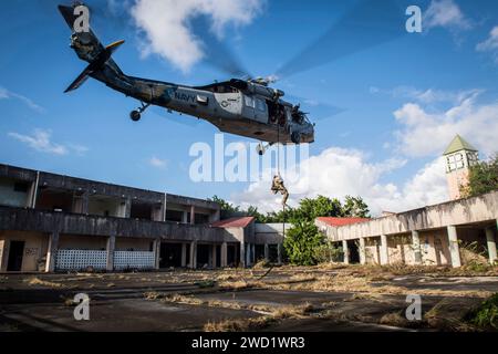 Ein Sprengstoffentsorgungstechniker schnappt sich aus einem MH-60S Sea Hawk Hubschrauber der US Navy. Stockfoto