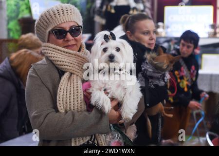 Madrid, Spanien. Januar 2024. Eine Frau trägt einen Hund in der Kirche San Anton während eines Gottesdienstes am Tag des Heiligen Antonius. Während des Tages des Heiligen Antonius des Abbotten, des schutzheiligen der Tiere, bringen Hunderte von spanischen Tierbesitzern ihre Tiere in die Kirche San Anton in Madrid, um sie segnen zu lassen. Quelle: SOPA Images Limited/Alamy Live News Stockfoto