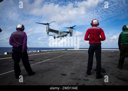 Seeleute beobachten, wie ein MV-22B Tiltrotor auf dem Flugdeck der USS New Orleans landet. Stockfoto