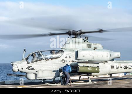 Sailor an Bord des amphibischen Transportdocks USS Somerset entfernt Ketten von einer AH-1Z Viper. Stockfoto