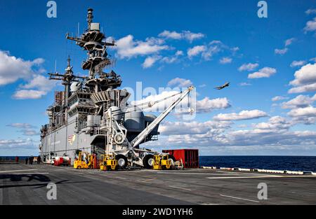 Ein P-8A Poseidon-Flugzeug fliegt am amphibischen Angriffsschiff USS Wasp vorbei. Stockfoto