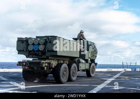 Die US-Marines stellen ein HIMARS-Fahrzeug auf dem Flugdeck eines Schiffes auf. Stockfoto