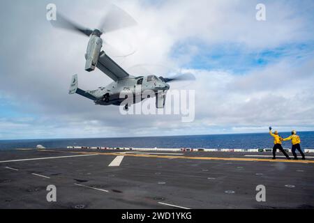 US-Seeleute leiten eine MV-22 Osprey zum Start vom Flugdeck der USS Makin Island. Stockfoto