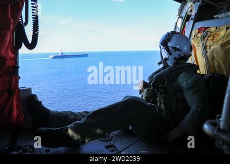 Marinescrewman steht für den Flugzeugträger USS Gerald R. Ford in einem MH-60S Sea Hawk Helikopter. Stockfoto