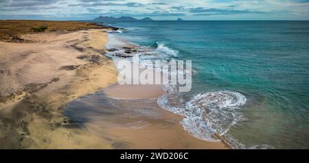 Ein Panoramablick auf den Sandstrand in São Vicente, Kap Verde, fängt die ruhigen Wellen ein, die über den goldenen Sand ziehen, während der Kontrast vom Dramat steht Stockfoto