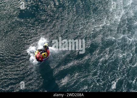 Ein Überlebenstechniker der Luftfahrt stürzt mit einem MH-60 Jayhawk Hubschrauber ins Wasser. Stockfoto